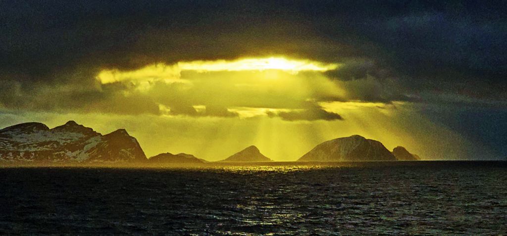 Die bewölkte Sonne über der Küste von Norwegen