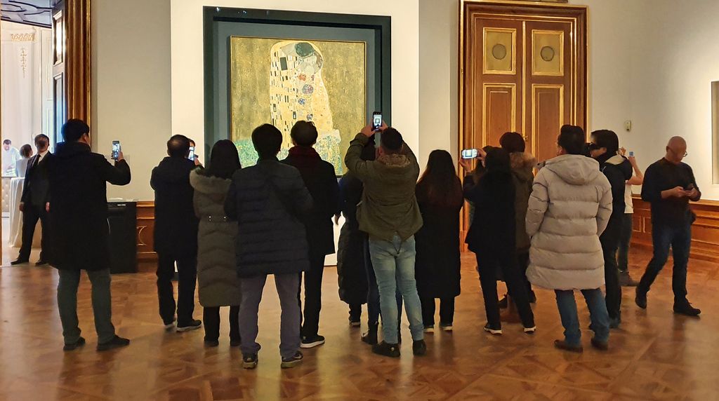 Besucher vor Der Kuss von Gustav Klimt